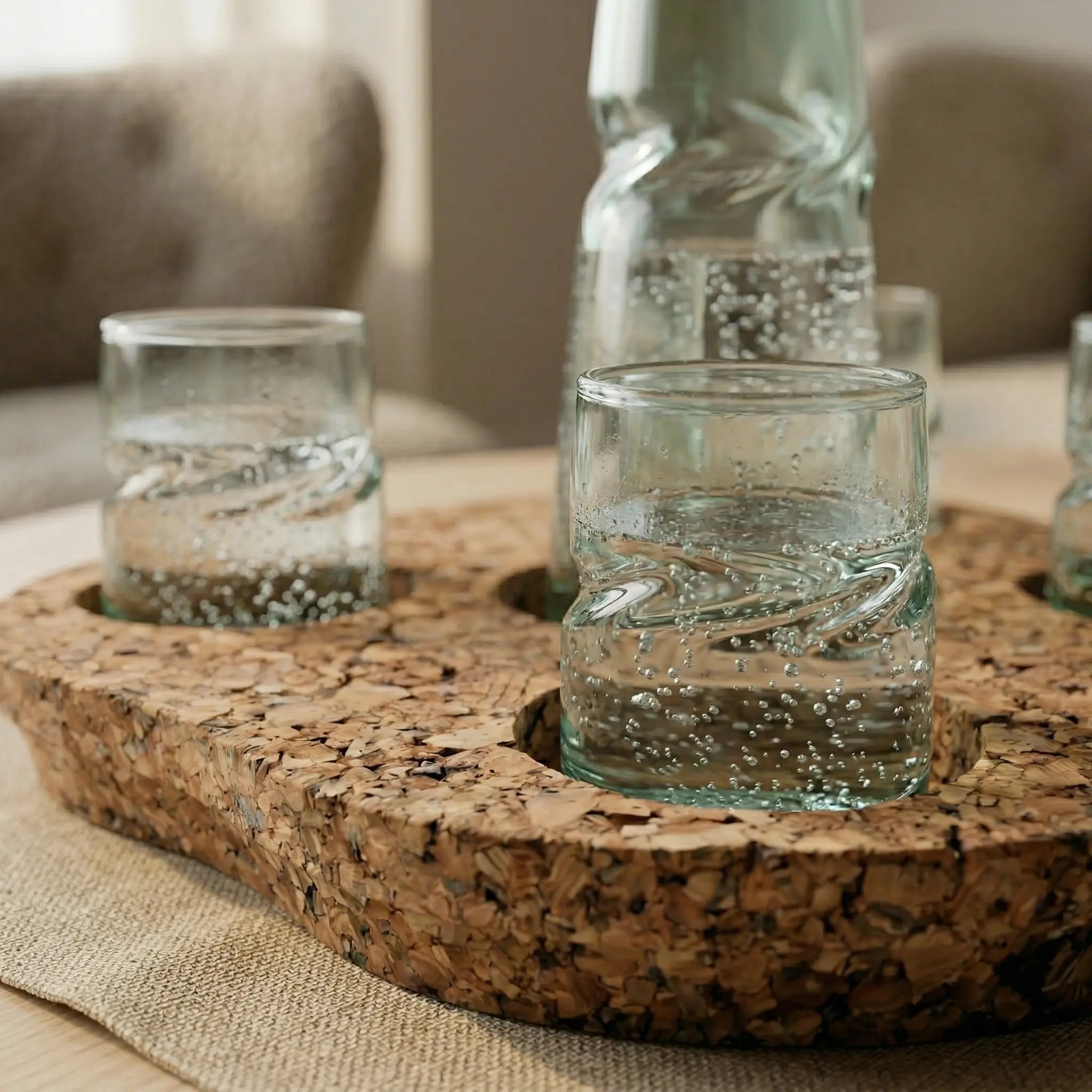 Clear VISLA glass tumblers on a cork coaster with a blurred background