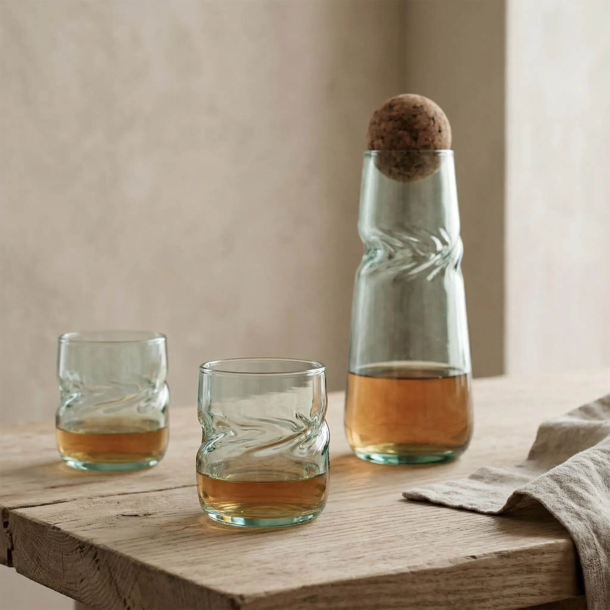 VISLA Whiskey glasses and a carafe with liquid on a wooden surface.